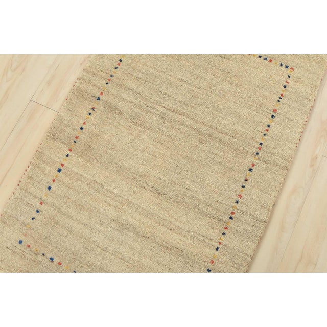 A contemporary Gabbeh rug hand-knotted with an all-wool pile on a cotton foundation. This finely woven oriental rug...