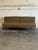This striking armless sofa features a streamlined silhouette highlighted by an architectural exposed back support. The...