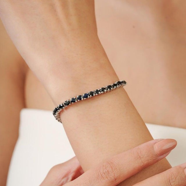 This stunning 925 sterling silver blue sapphire tennis bracelet features an elegant row of brilliant blue sapphires...