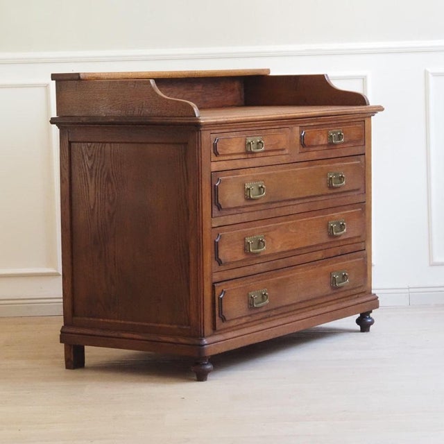 This impressive chest of drawers with an attached mirror dates from around 1900 and combines a classic chest of drawers...