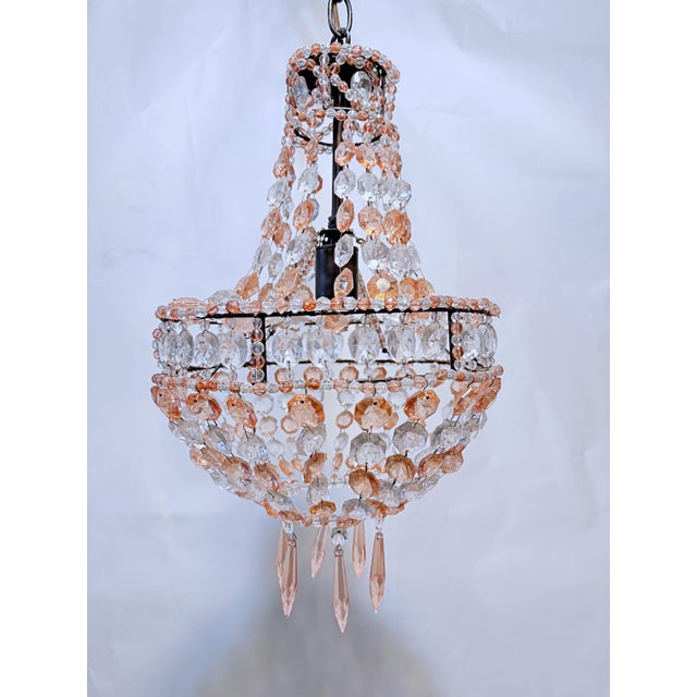 This is a beaded empire style chandelier with octagon shaped crystal clear and rosaline beads. It has one Edison based...