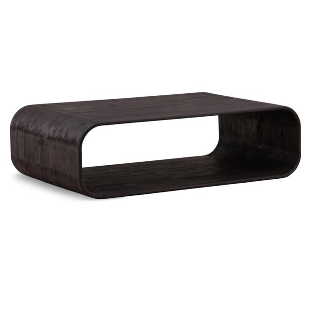 Sculptural modern coffee table crafted from solid wood in a rich black finish. Its minimalist continuous form creates a...