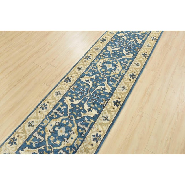 A modern tribal Oushak runner hand-knotted with an all-wool pile on a cotton foundation. This oriental rug features a...