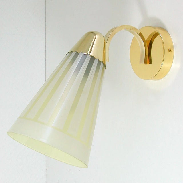 This elegant large midcentury wall light was designed and manufactured in Germany in the 1960s. It is made of brass and...