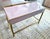 This superb desk / vanity is made of reverse-painted glass panels in a beautiful soft pink color and solid brushed brass...