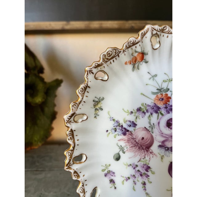 There is quite a story to this floral, scalloped & gilded gold collectible. The artist, Franziska Hirsch, between 1894 and...