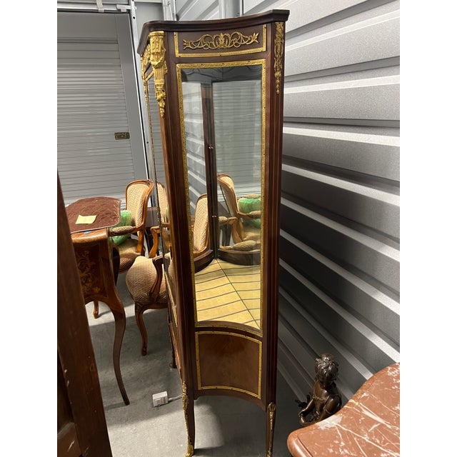 Beige marble top, simple glazed door cabinet with marquetry lower panel flanked by concave glazed side panels with...