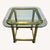 Elegant vintage 1970s Hollywood Regency brass and glass end table. This sophisticated piece features a heavy, solid brass...