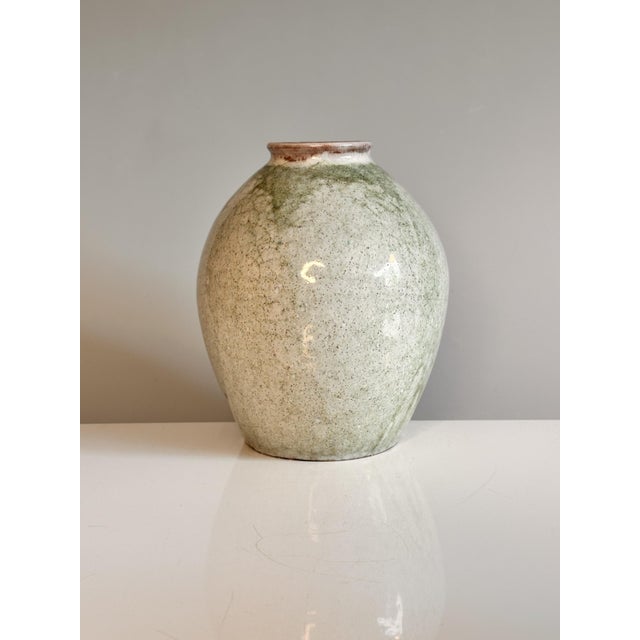 Handcrafted and signed studio ceramic vase from 1976, featuring a softly rounded, classic vase shape and a gently...