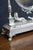 Ornate oval tabletop vanity mirror featuring an elaborate silver-tone frame with scrolling openwork, a decorative crest...