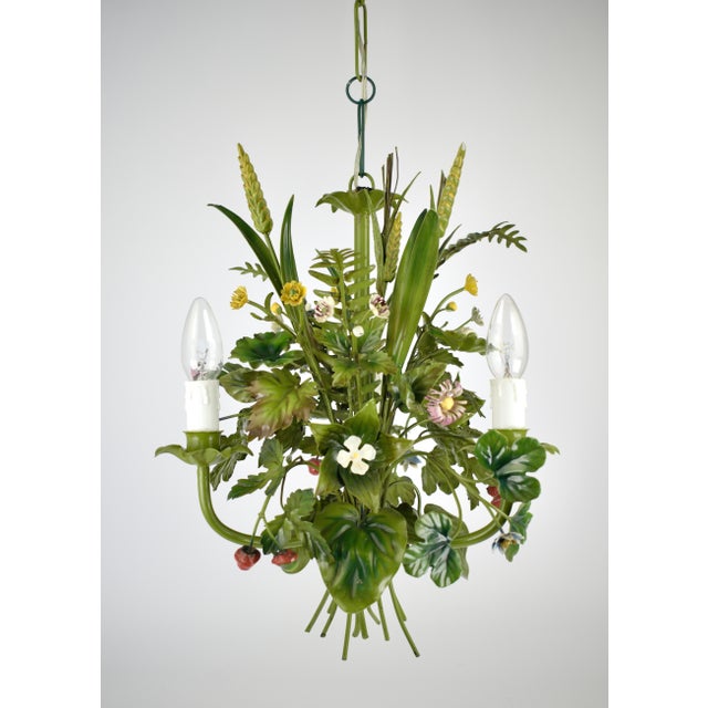 Elegant French chandelier in painted toleware, decorated with field flowers. This vintage, mid-century piece has a relaxed...