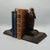 A pair of carved wooden marabou stork bookends each with beaks tucked into their chests. Dimensions: h 21cm w 11.5cm d...