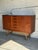 This expansive credenza features twin cabinet doors flanking five center drawers with integrated carved pulls. Raised on a...