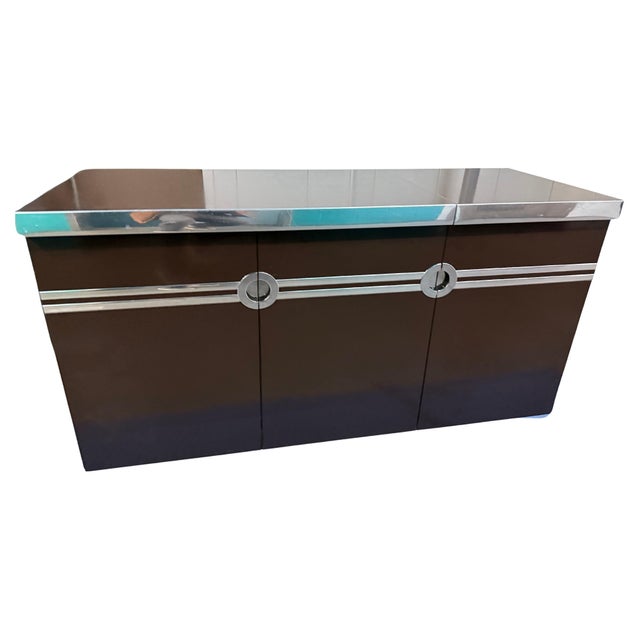 Lift-top bar unit in brown with chrome banding and pulls by Pierre Cardin, American, 1970s (signed "Pierre Cardin"). Top...