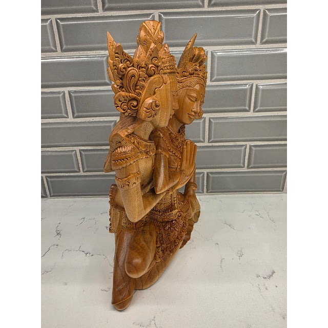 A beautifully stylized, highly decorative late 20th-century Balinese modernist wood carving capturing the divine bridal...