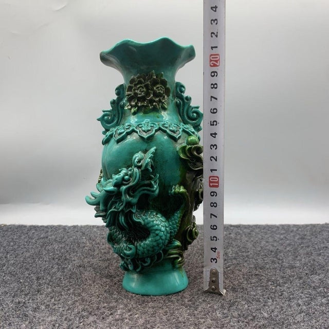 This striking pair of vases features rich, high-relief sculptural decoration in a vibrant turquoise glaze. One vase...