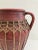 A vintage Mediterranean or Southeast Asian terracotta amphora featuring a deep red oxide finish and intricate handwoven...