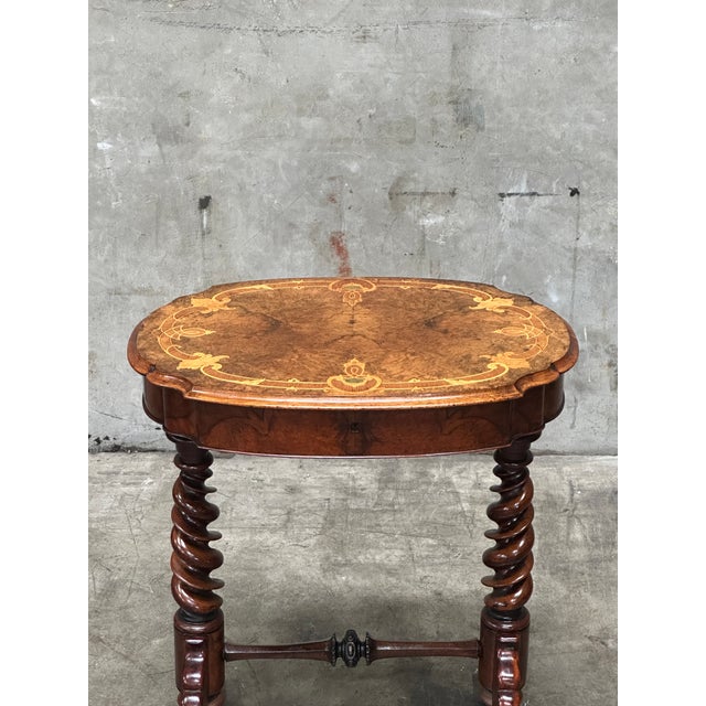 A beautifully crafted 19th century English sewing table in richly figured burl walnut, elevated by elegant barley twist...