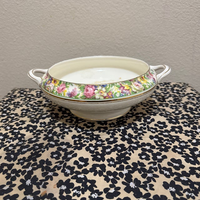 A dense, multicolored floral chintz band featuring pink roses, daisies, and delicate greenery, accented with elegant gold-...