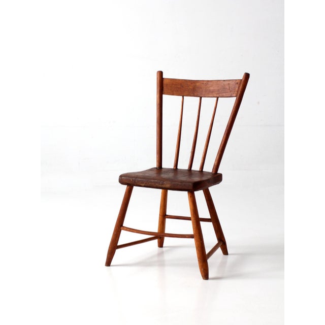 A 19th century plank seat chair with a beautifully worn surface and classic country form. The shaped wooden seat, fan-back...