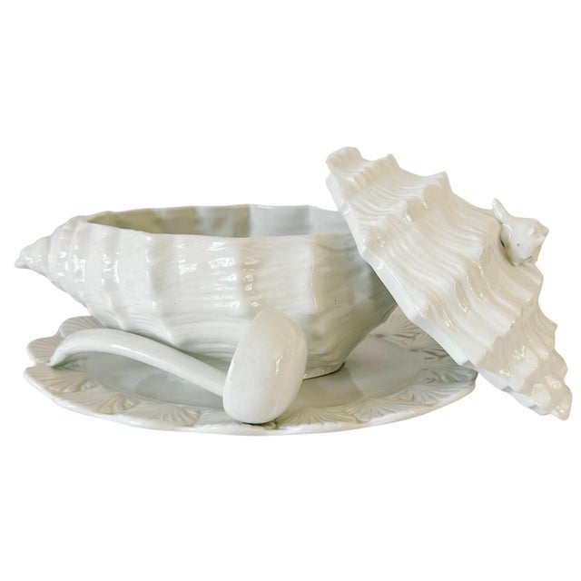 A four-piece vintage Italian porcelain soup tureen set modeled as a sculptural white conch shell. Featuring a matching...