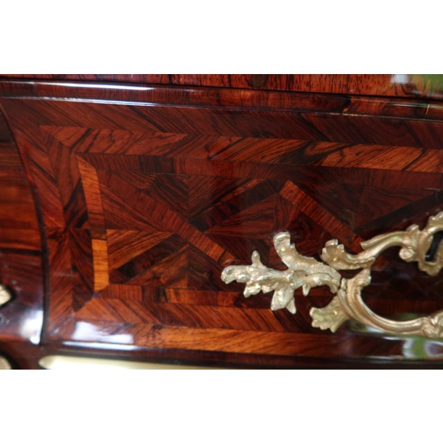 A strongly curved commode, veneered and inlaid on all sides. It opens with four drawers: two in the upper section and two...