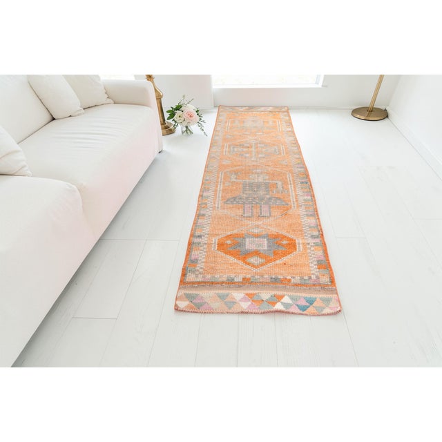 This is a vintage Turkish Oushak rug from the Mid 20th Century. The piece was hand-knotted.