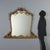 Carved and gilded wooden table mirror, featuring an openwork frame with elaborate scrolls, curls, flowers, and leaves that...