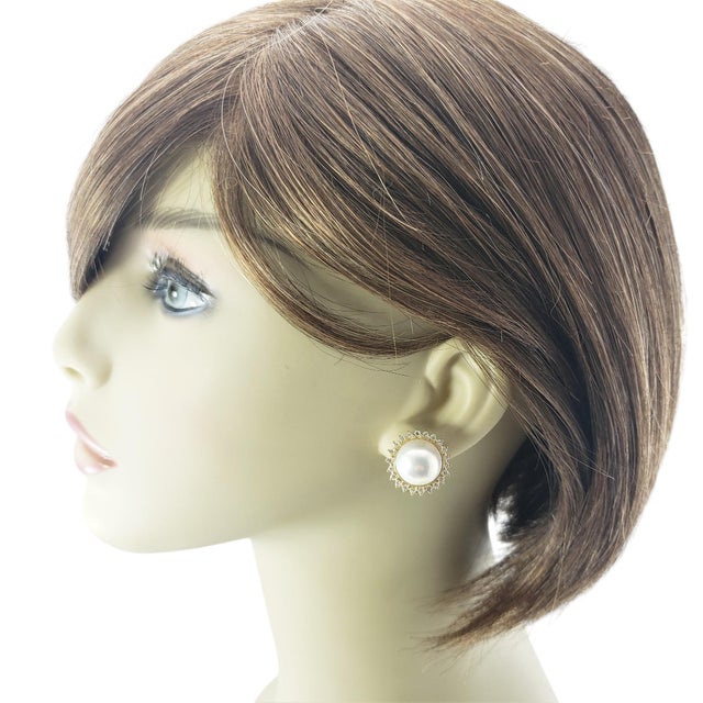 These lovely earrings each feature one round white mobe pearl (13 mm) surrounded by 22 round brilliant cut diamonds....