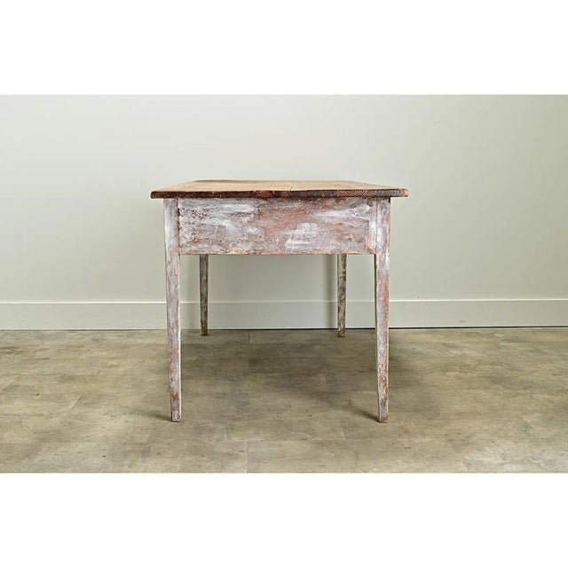 A rustic Gustavian painted pine table from the 1820s, Sweden. The waxed pine table top is removable and rests on a painted...