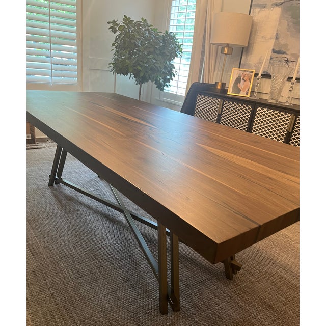 Arhaus Nika dining table. Solid wood top with a dark finish and natural wood grain details. Metal A-frame style base, dark...