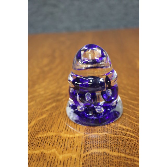 Handcrafted art glass paperweight featuring a rich cobalt blue interior encased in clear crystal with a ring of controlled...