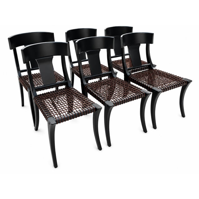 Klismos black dining chairs. The chairs are made of solid alder with a satin finish and leather strapping. The chairs are...