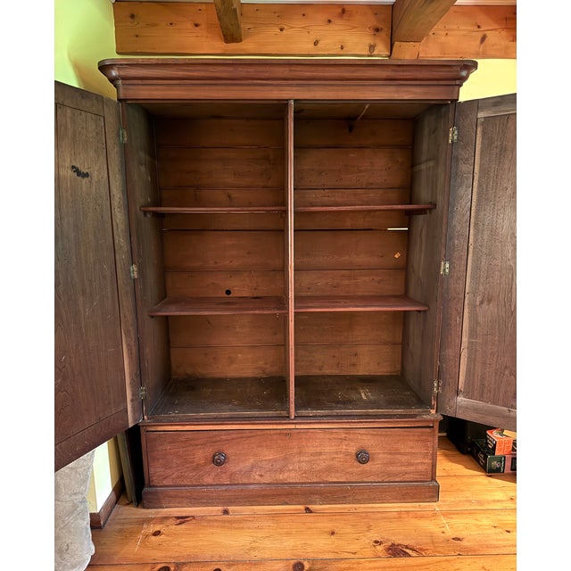 Elevate your space with this stately mid-19th century vintage armoire, crafted from solid cherry wood with rich, warm...