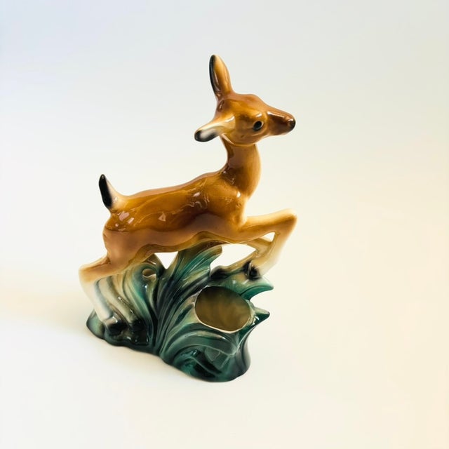A mid century ceramic planter in the shape of a deer leaping over grass. Finished in green and brown glossy glazes. Plants...