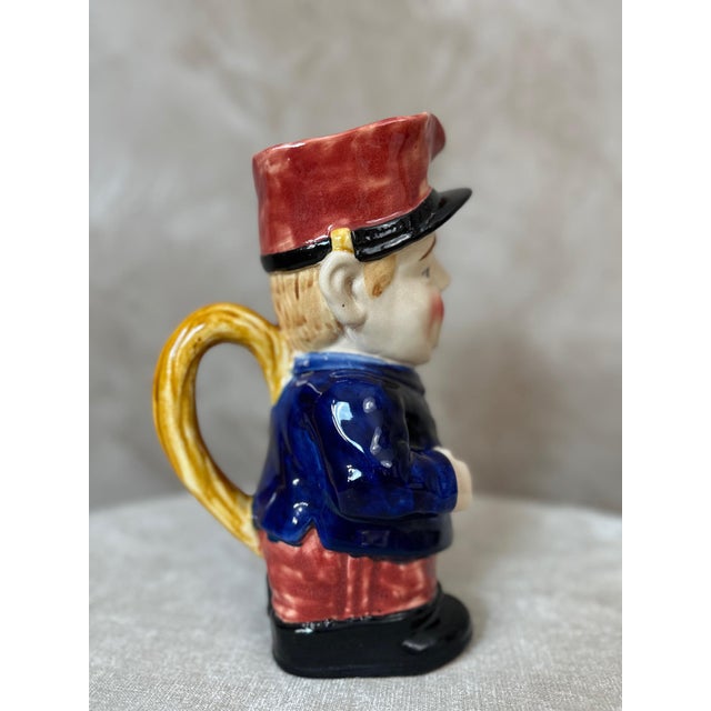 Charming earthenware pitcher dating from the early 20th century, humorously depicting a postman in his blue uniform and...