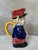 Charming earthenware pitcher dating from the early 20th century, humorously depicting a postman in his blue uniform and...