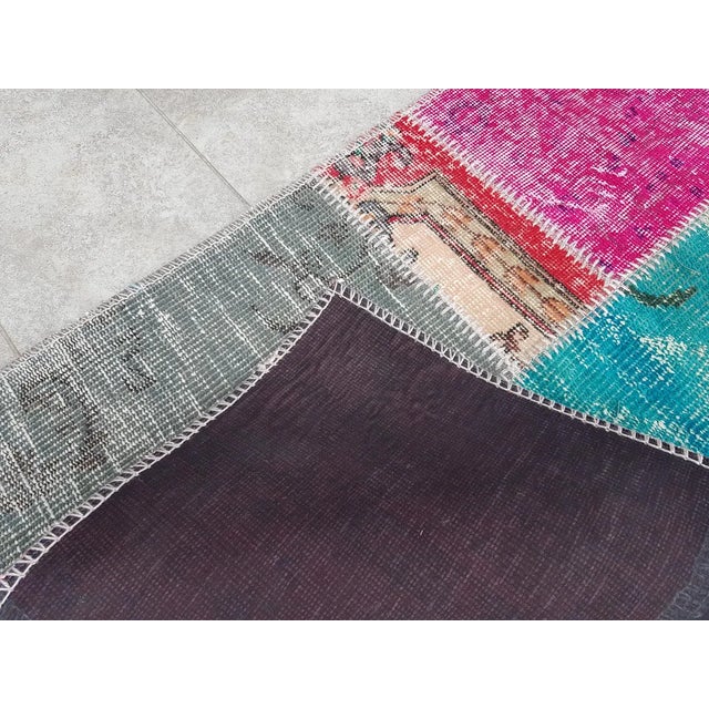 This is a vintage Turkish Oushak rug from the Mid 20th Century. The piece was hand-knotted.