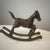 This vintage brass rocking horse features a detailed design with a dynamic pose and engraved saddle details. Its aged...