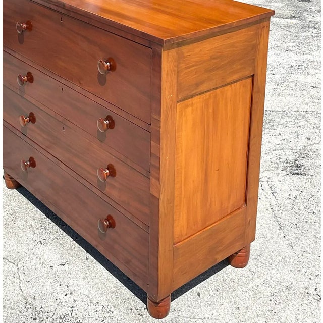 An exceptional vintage flame mahogany chest of drawers, masterfully crafted from richly figured hardwood and showcasing...