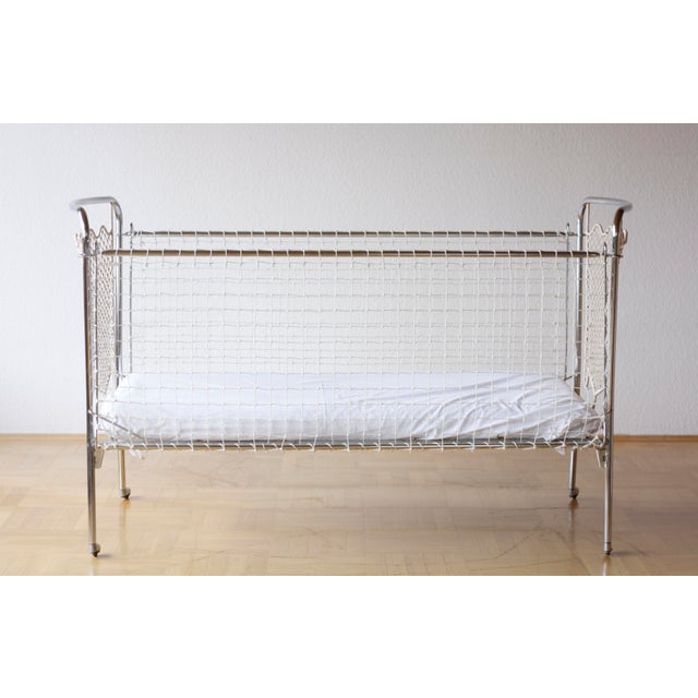 Well-maintained children's bed made of tubular steel with airy mesh sides and a woven headboard and footboard. Very good...