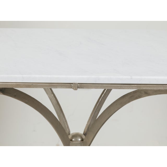 An Italian steel table from the mid 20th century, with white marble top and tripod base. Created in Italy during the...