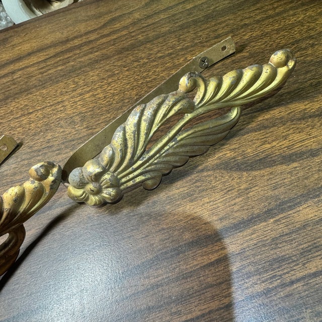 Pair of older acanthus leaves curtain tie backs made from a gilded metal. There are some dark spots and some pitting on...