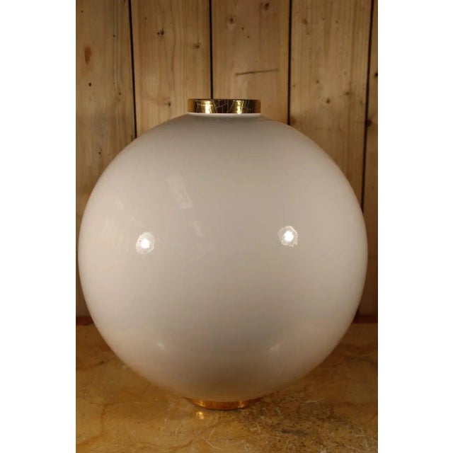 Large ball vase signed by the Longwy factory, gold neck and foot on a white background. Very large model. This piece has...