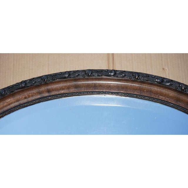 Oval wall mirror with original Mercury plate glass and heavily carved frame in Flamed Mahogany This mirror was pictured...
