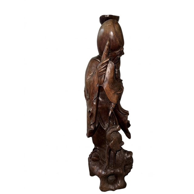A remarkably substantial and intricately carved wooden statue depicting the Chinese deity Shou Lao, the revered God of...
