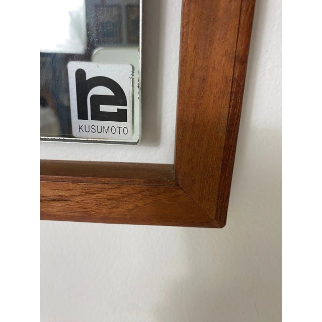 A mid-century teak wood wall mirror.