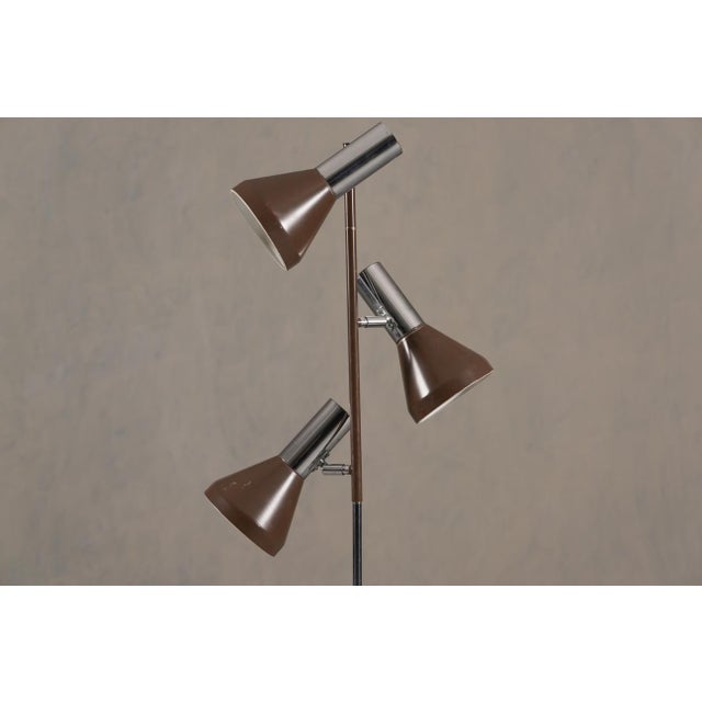 A vintage brown 3-bulb floor lamp from Germany, 1970s. The producer and designer are unknown. Made from metal and cast...