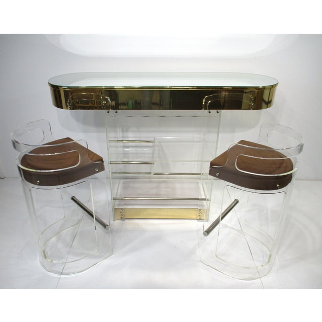 An exceptionally stunning Lucite light up bar with mirrored top and gold toned trim with two matching stools in ultra...