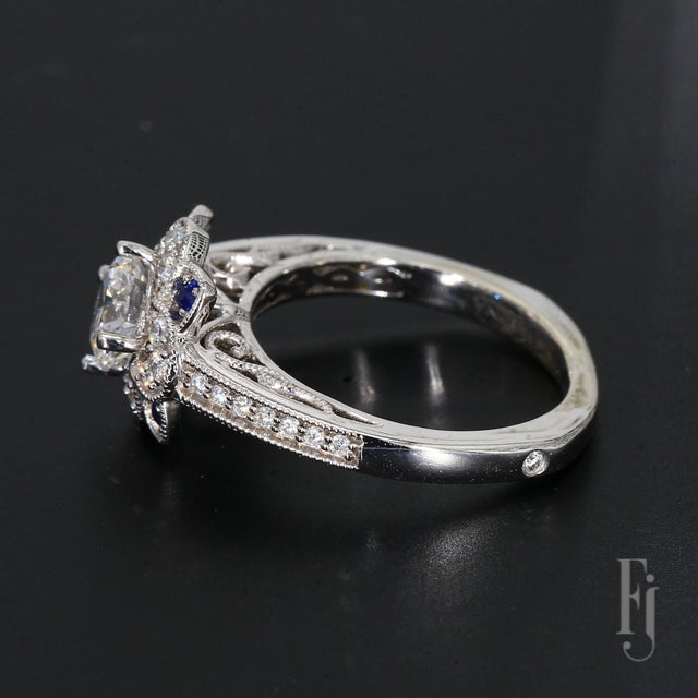 This is a 14k White Gold Ring with a European Shank Mounting & One 6.1mm Round Center Stone, Surrounded by Twenty-six...